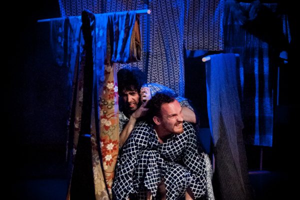 Naritsune (Andrew Woolner) and Yasuyori (Graig Russell) hide in an improvised shelter as the rain falls on Kikai-ga-shima.